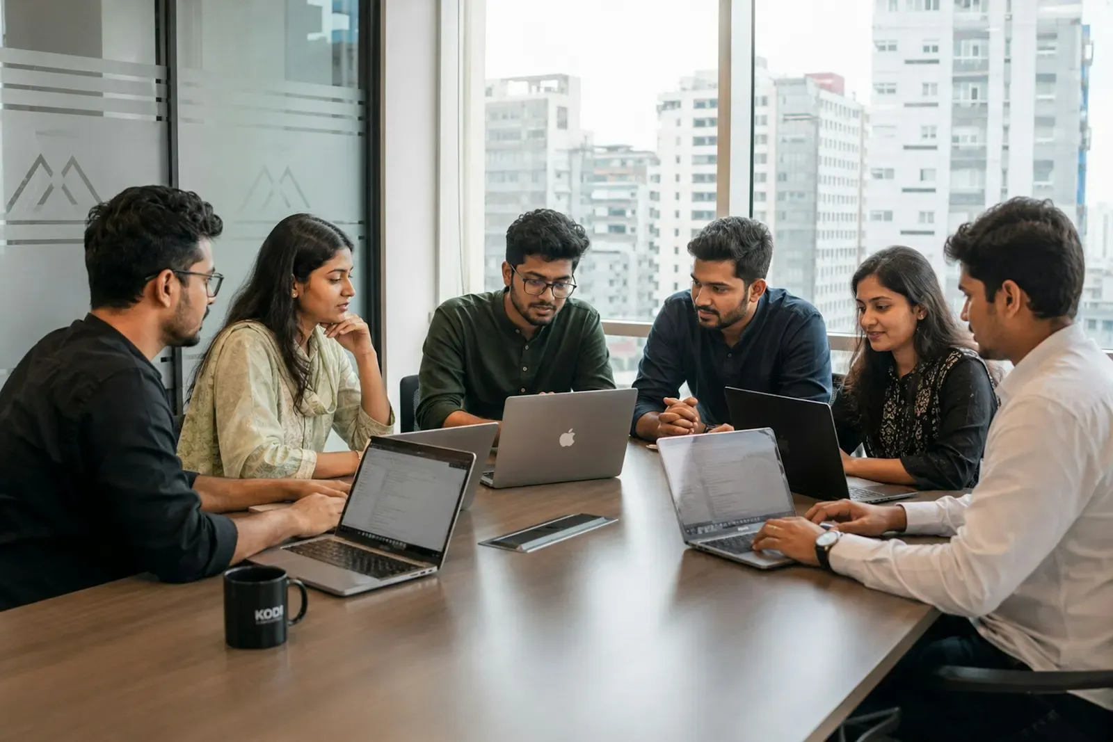 Engineering team working on laptops around a meeting table