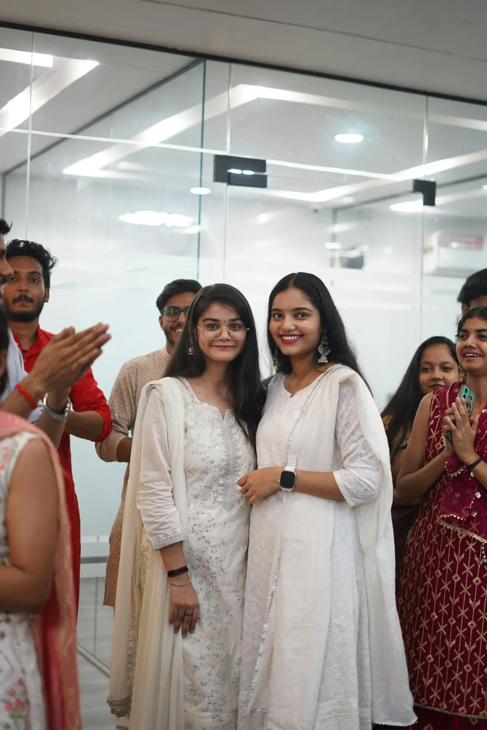 Colleagues smiling and clapping together at an office celebration