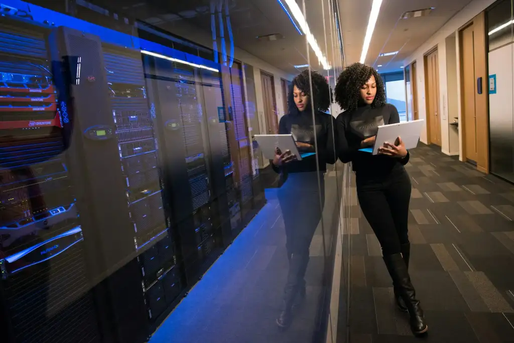 Engineer with a laptop beside server racks in a data center