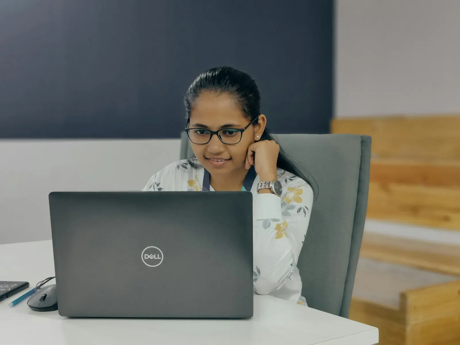 Smiling engineer seated at a desk with a laptop