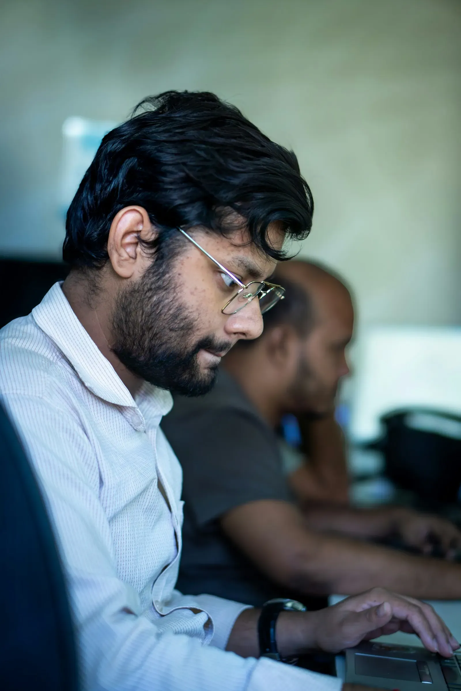 Engineer in glasses working beside a colleague