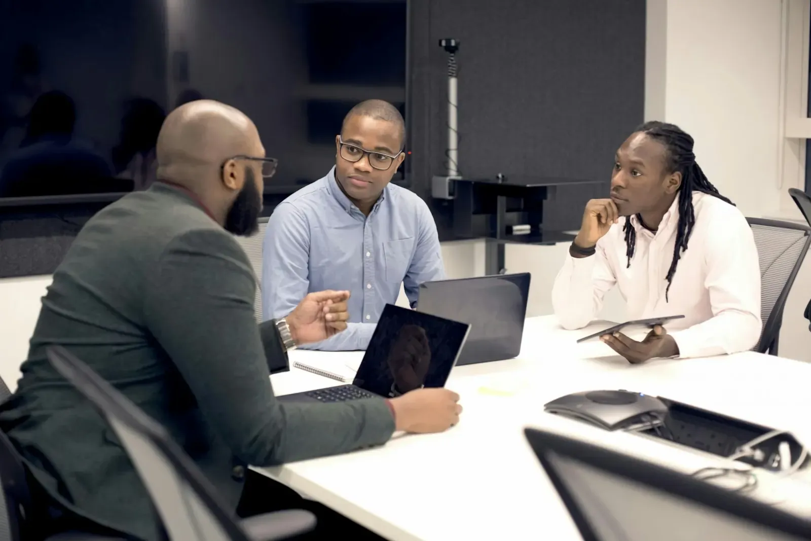Group of people working around a table with laptops