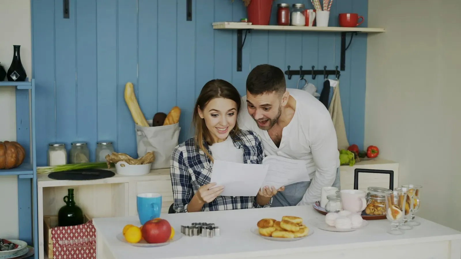 Couple reviewing papers in a bright kitchen
