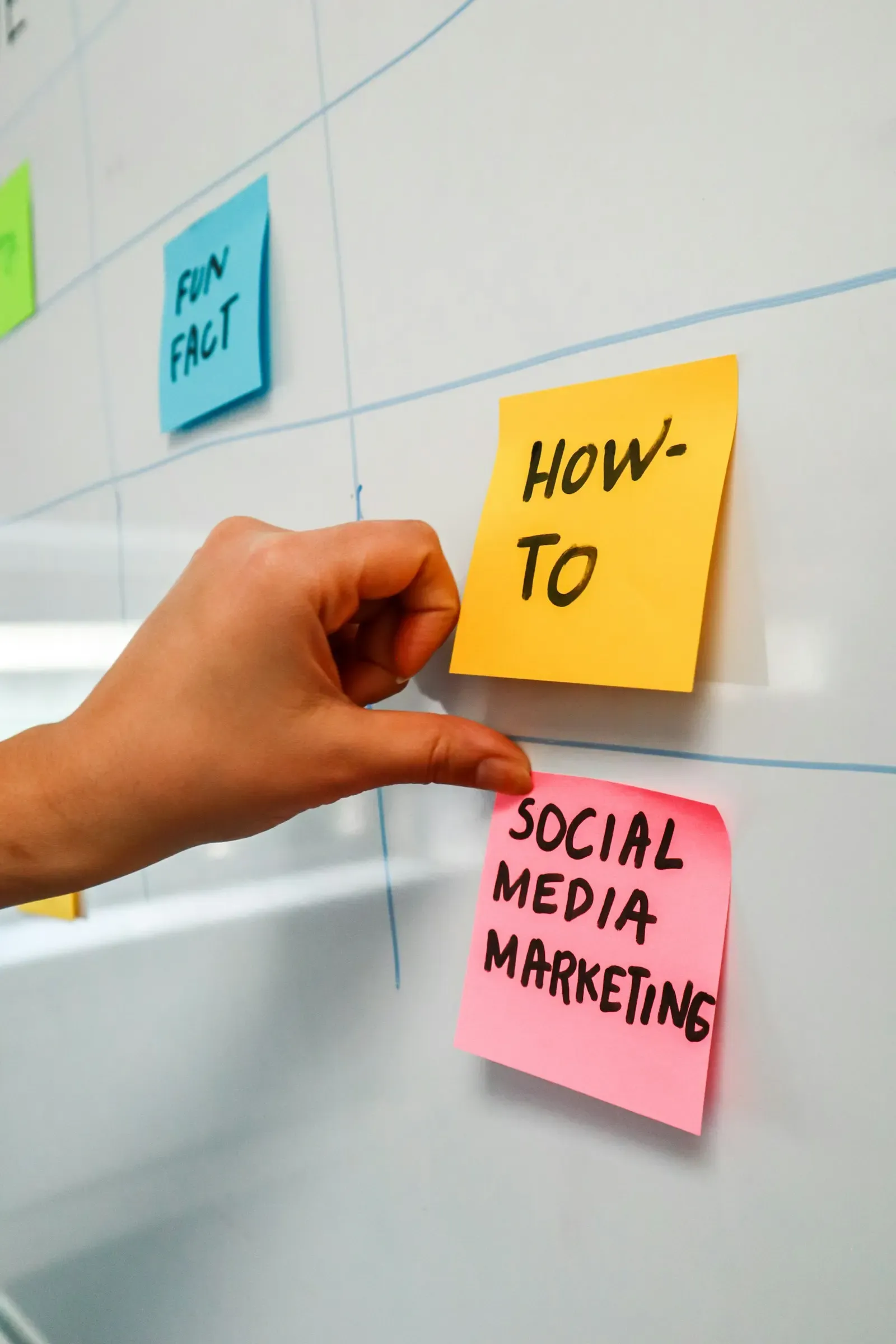 Hand pointing at sticky notes on a planning board