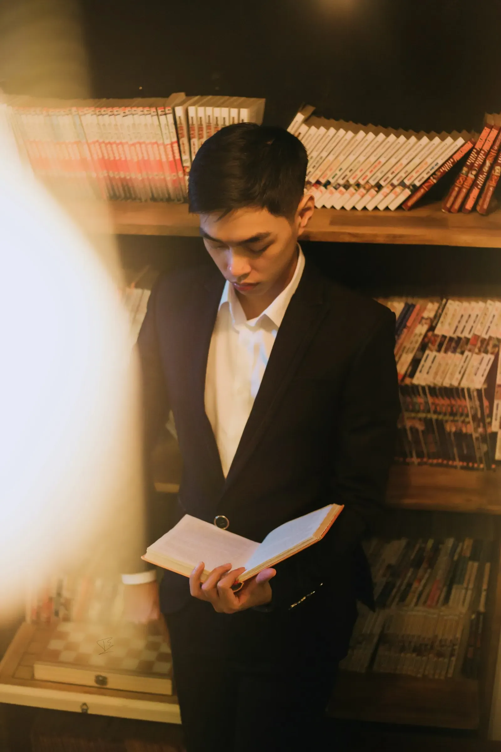 Lawyer in a dark suit reading a document in a library
