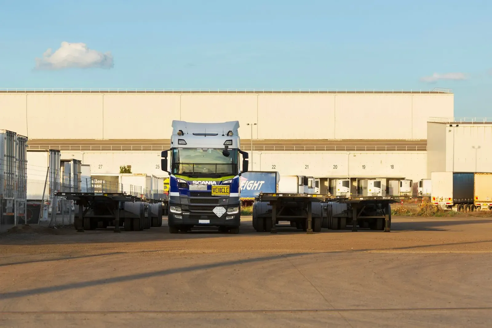 Lorries and trailers parked in front of a large warehouse