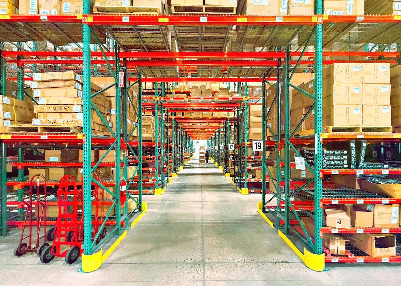 Warehouse aisle with tall racks of boxes on pallets