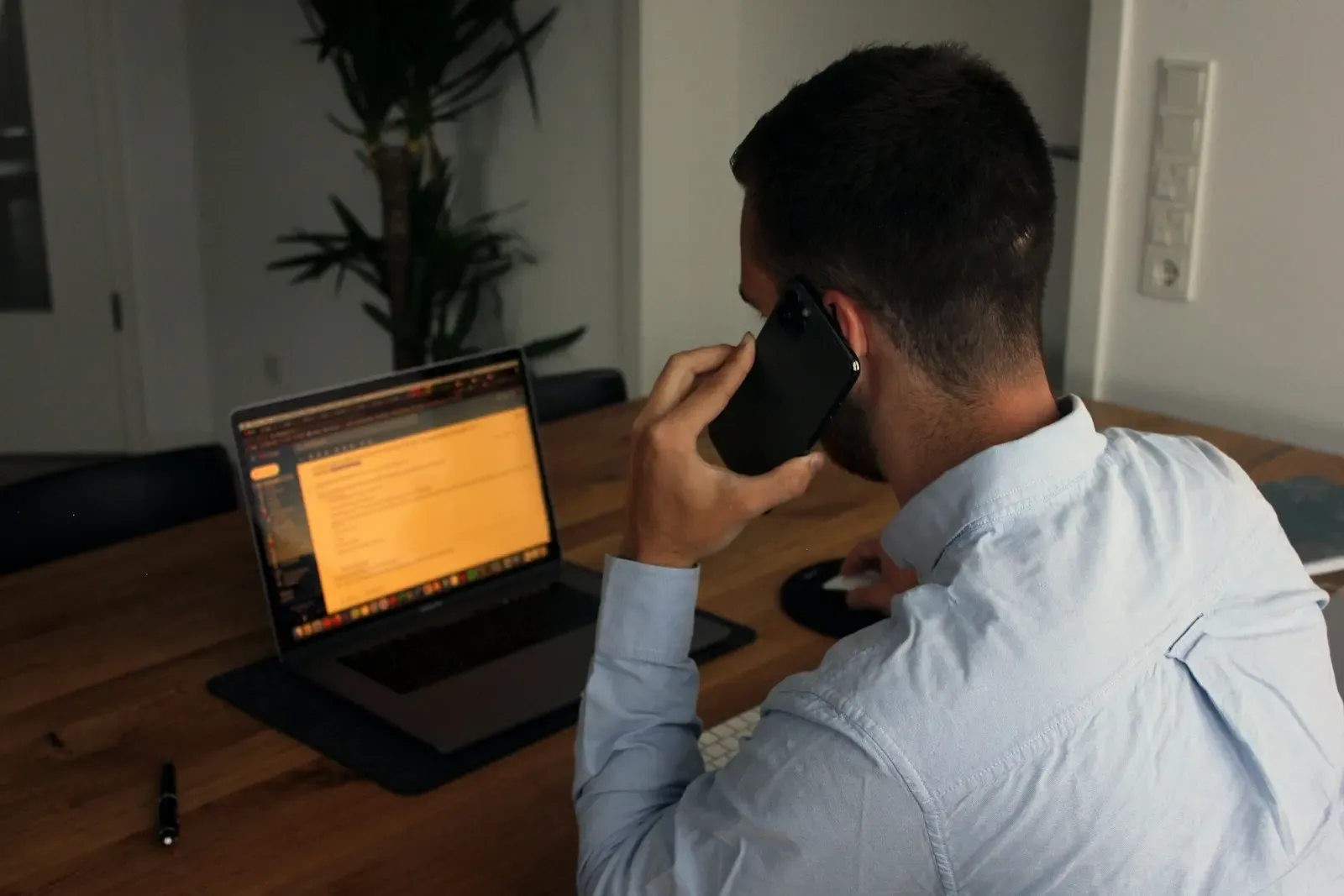 Sales rep on a phone call at a desk with a laptop