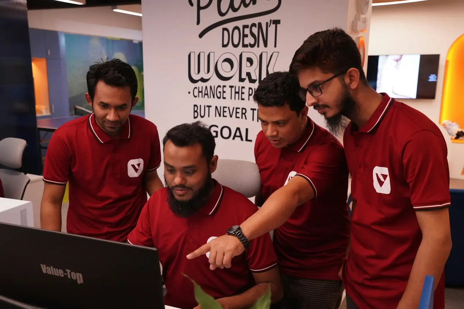 Team gathered around a laptop reviewing results