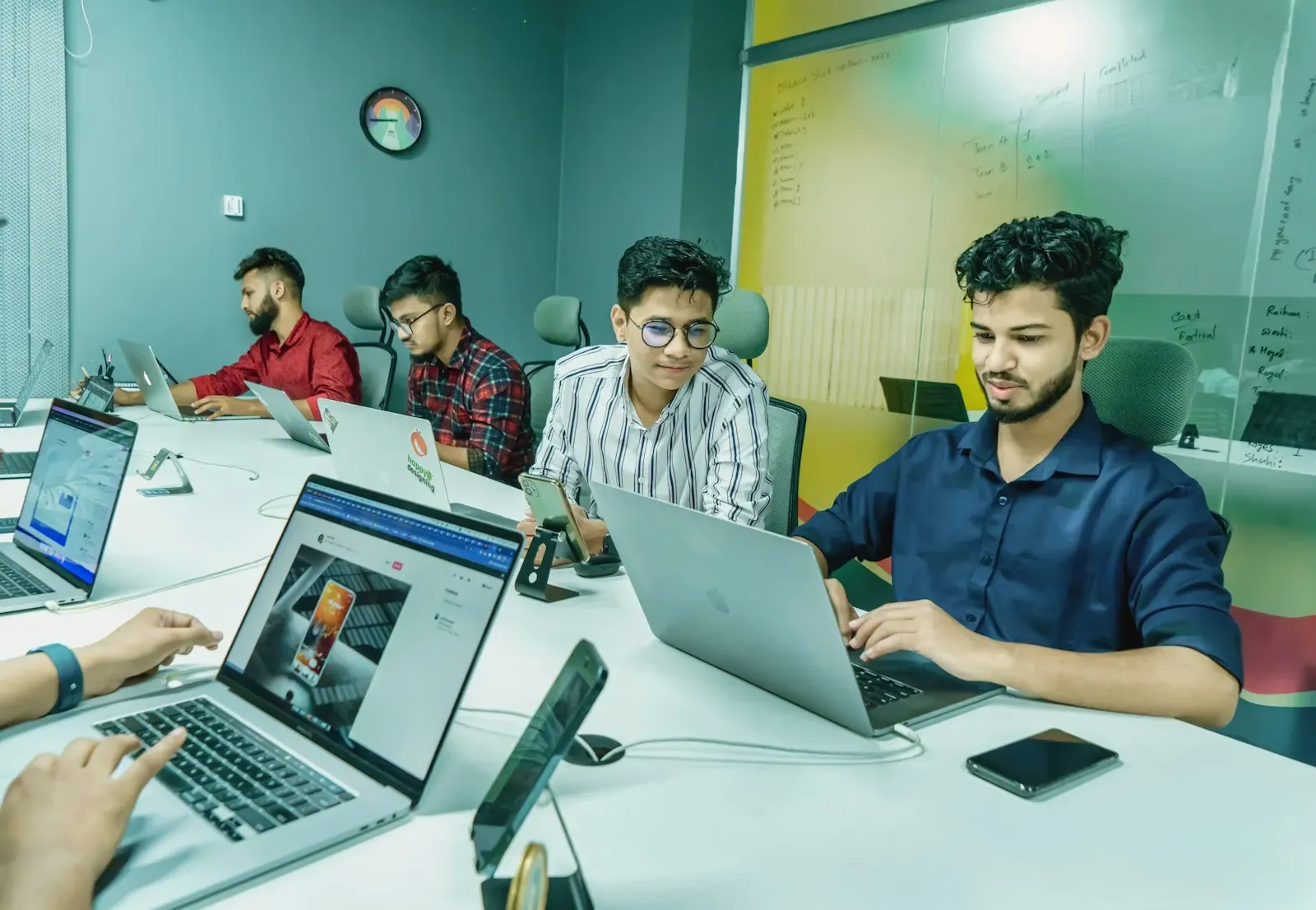 Security team working on laptops around a table