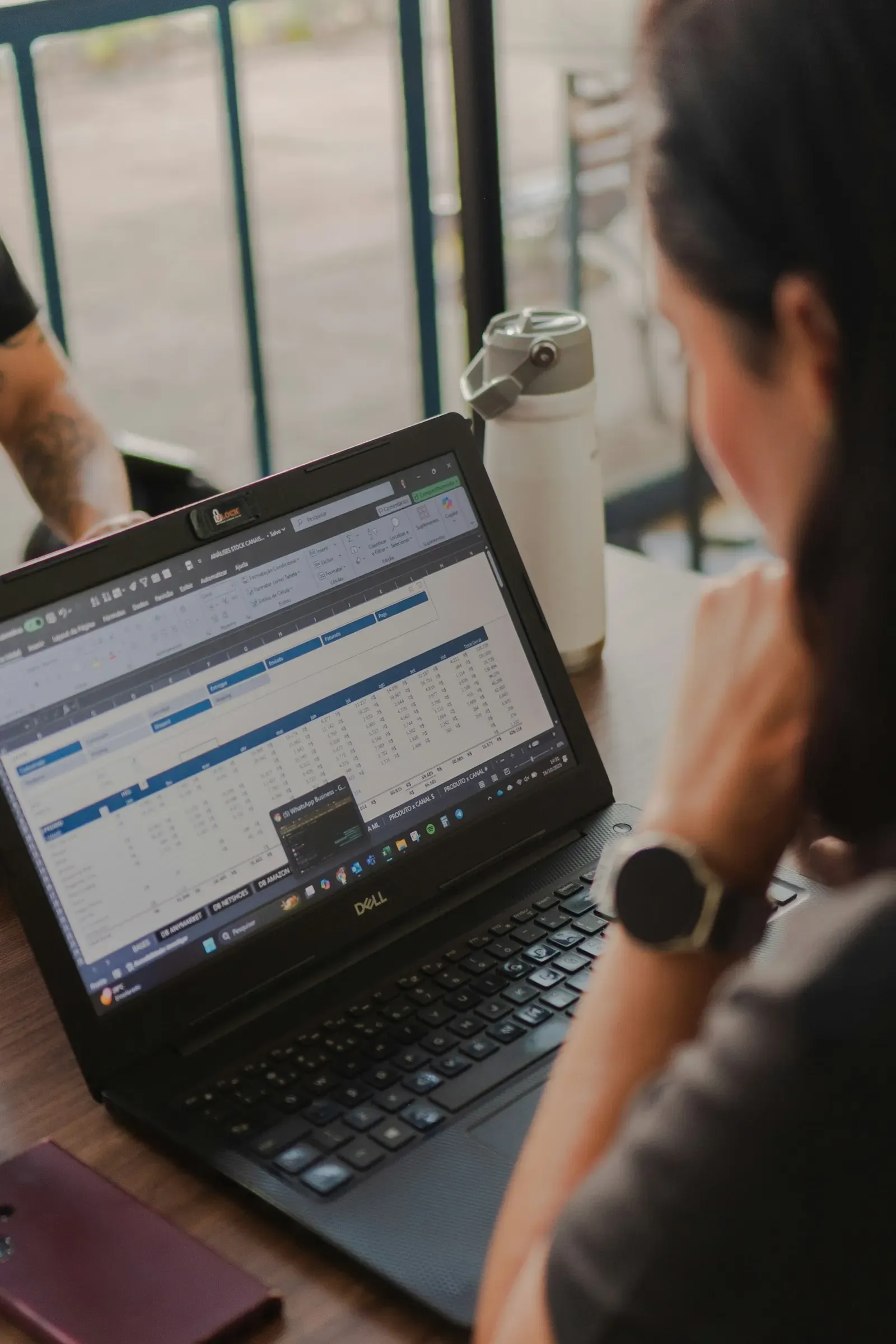 Analyst working through spreadsheet data on a laptop
