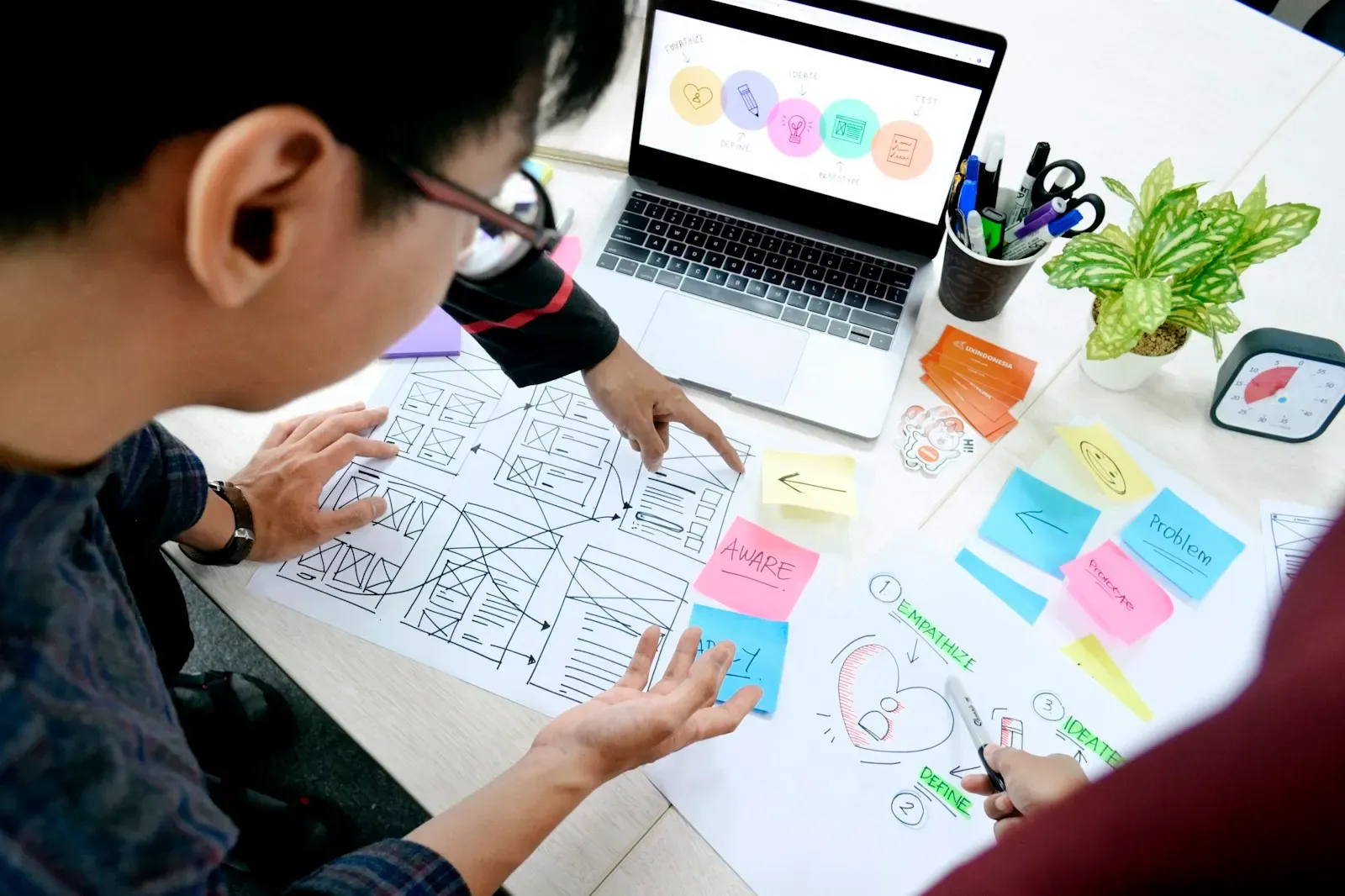 Product specialist sketching a workflow beside his laptop