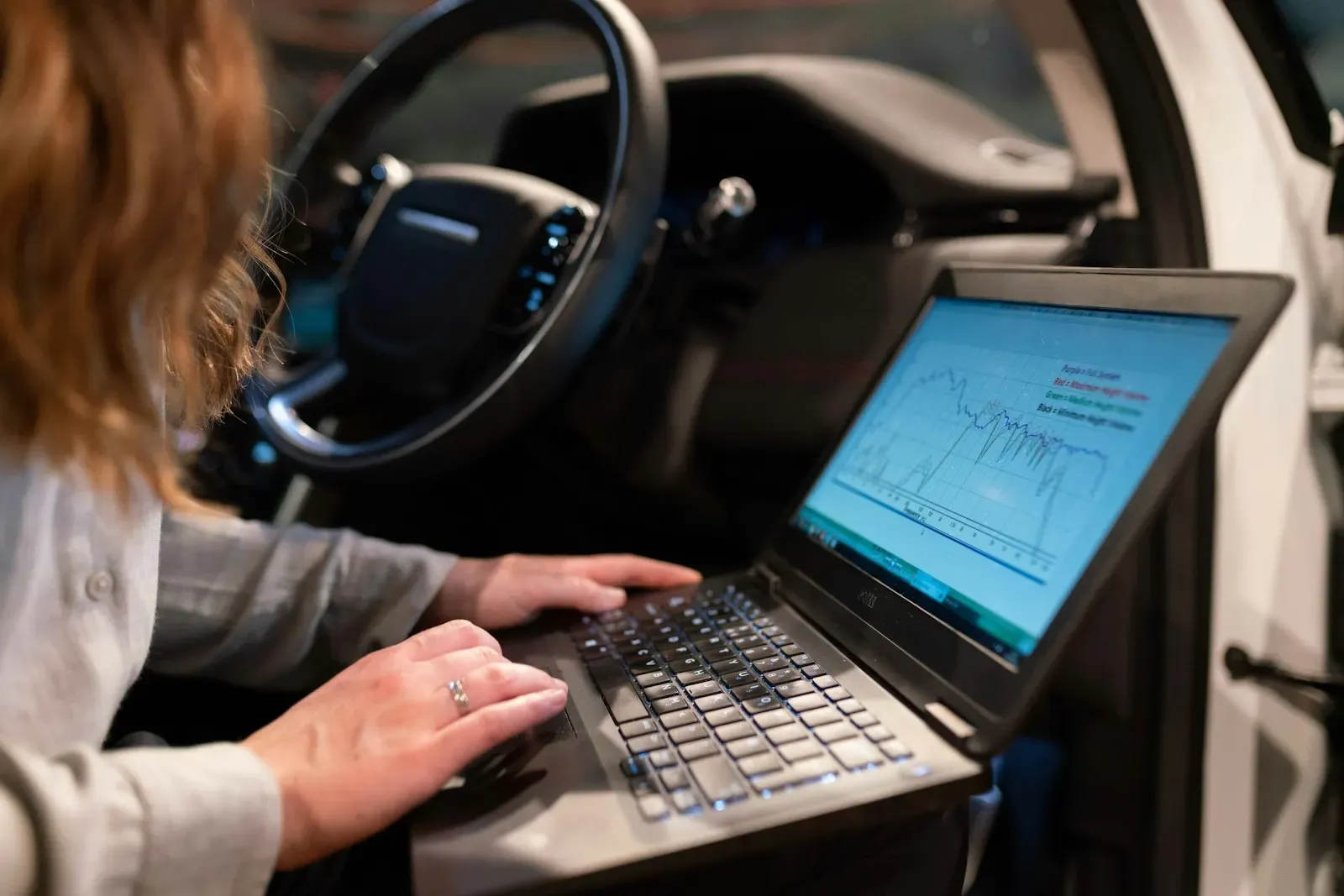 Technician running vehicle diagnostics on a laptop