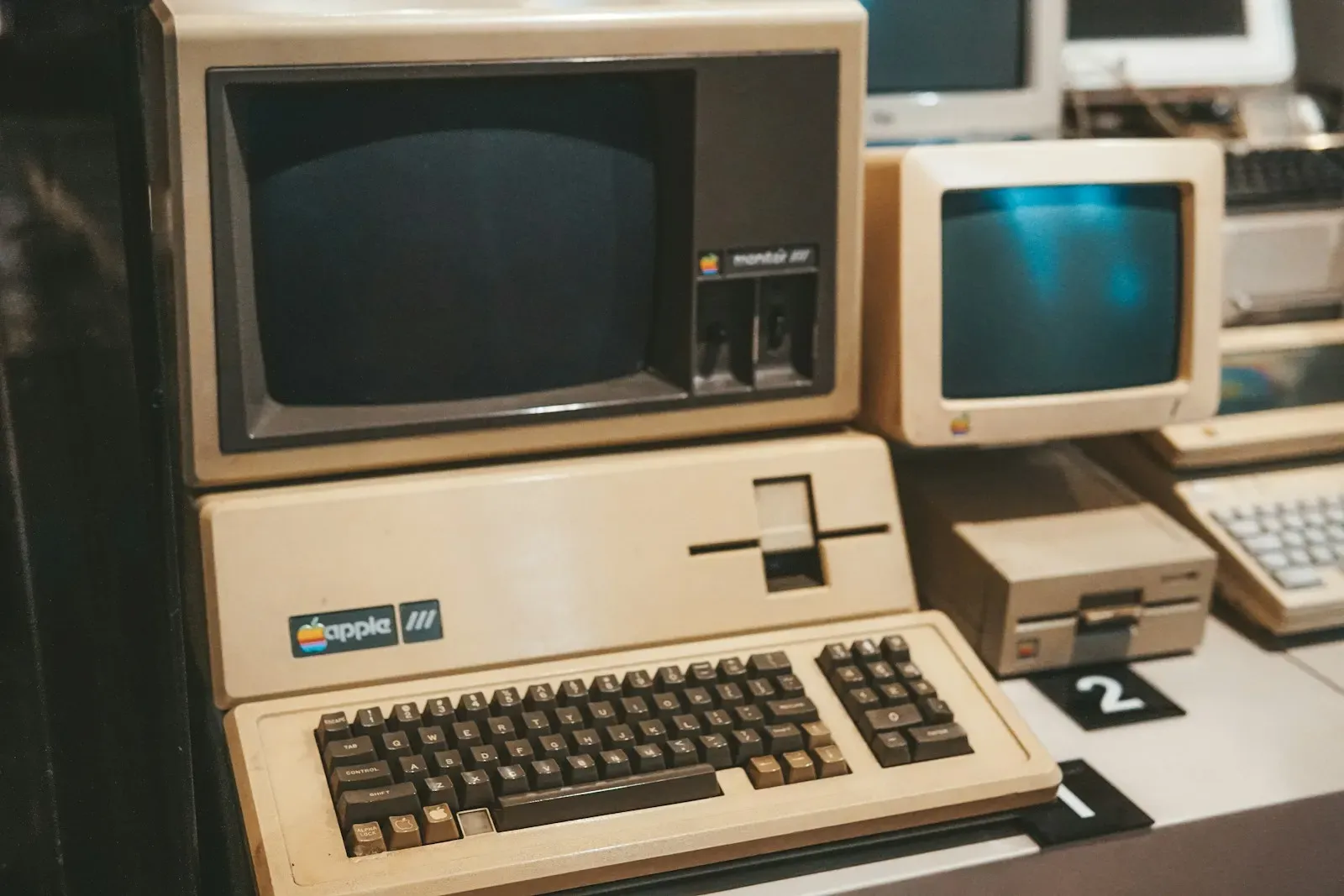 Row of older desktop computers and keyboards