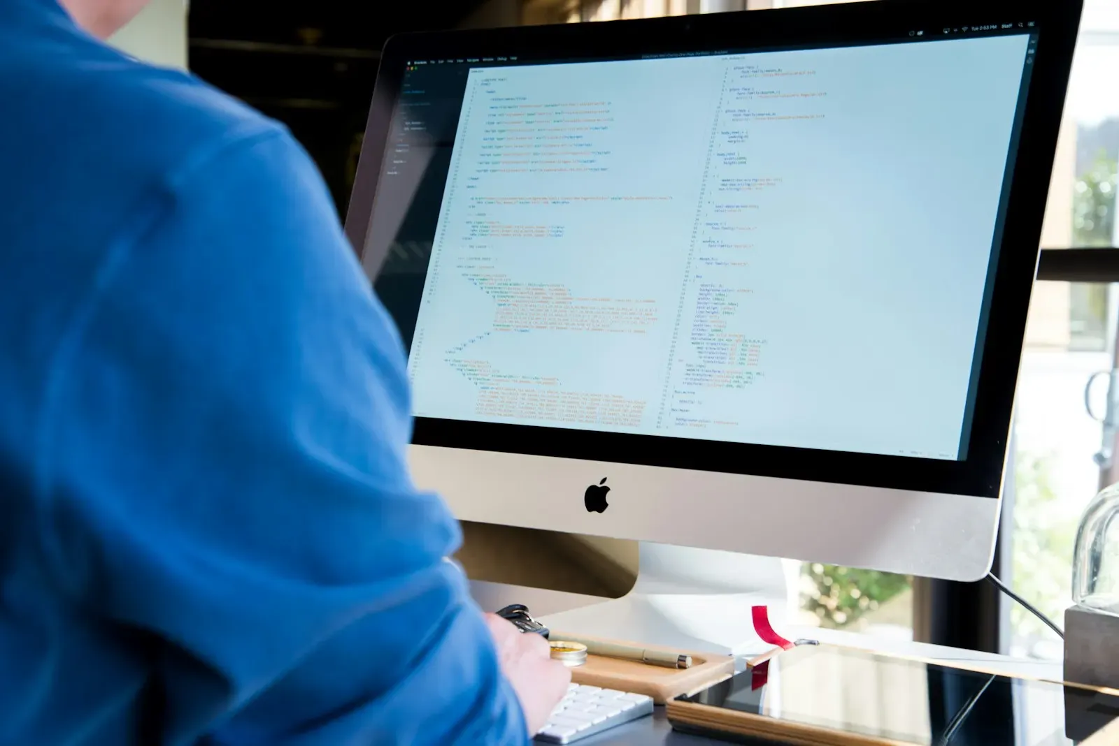 Person working at a desktop computer in a bright office