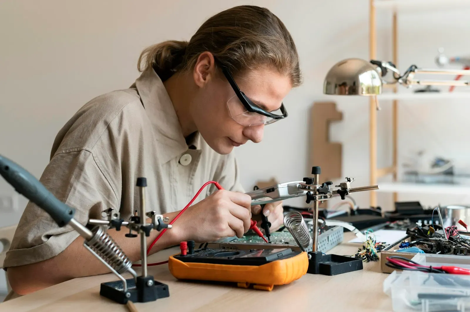 Technician testing an electronic circuit at her bench