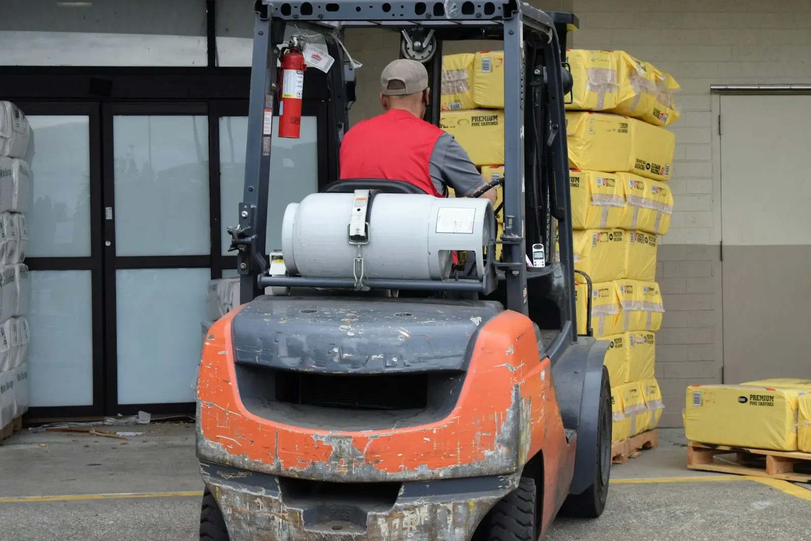Worker driving a forklift through a warehouse