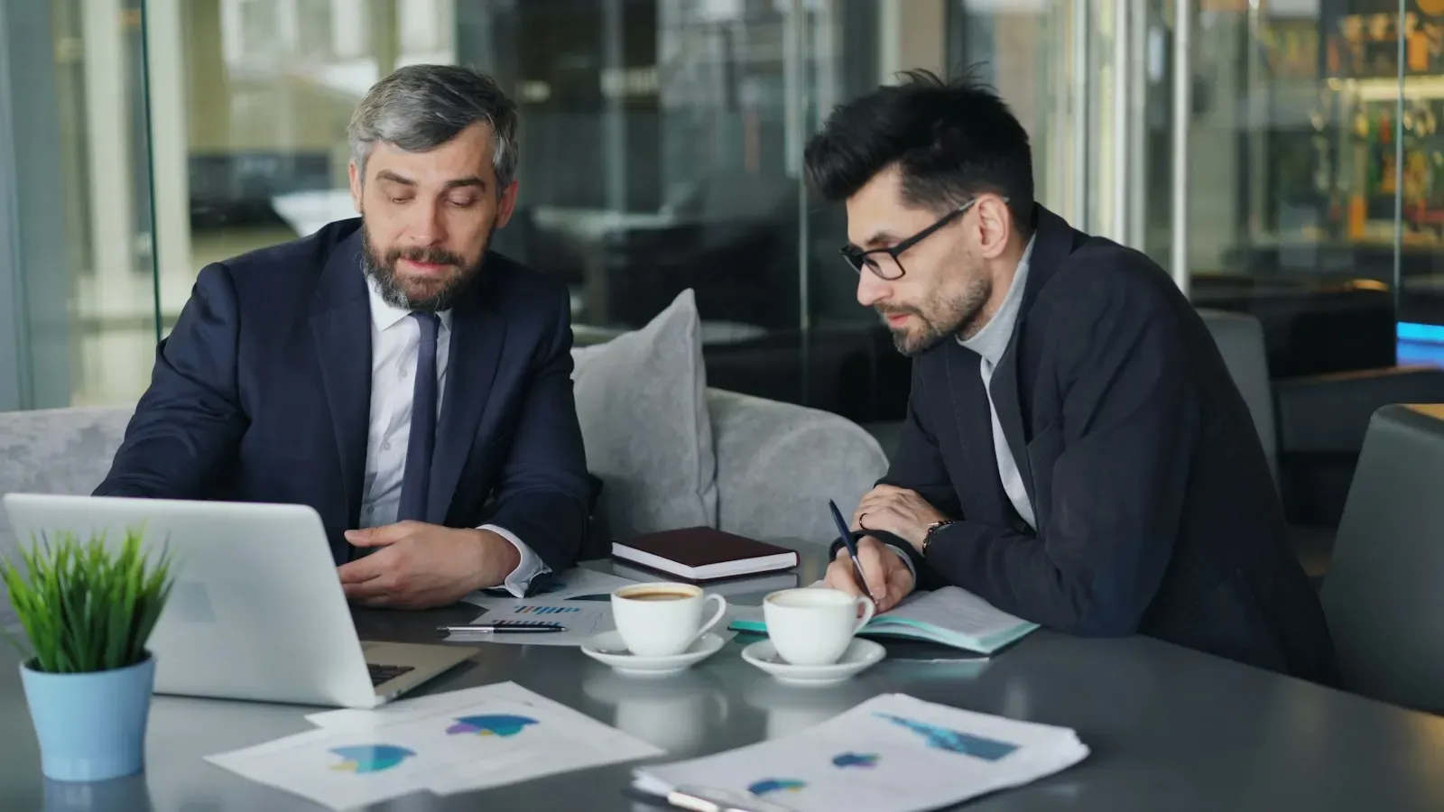 Two colleagues reviewing figures on a laptop