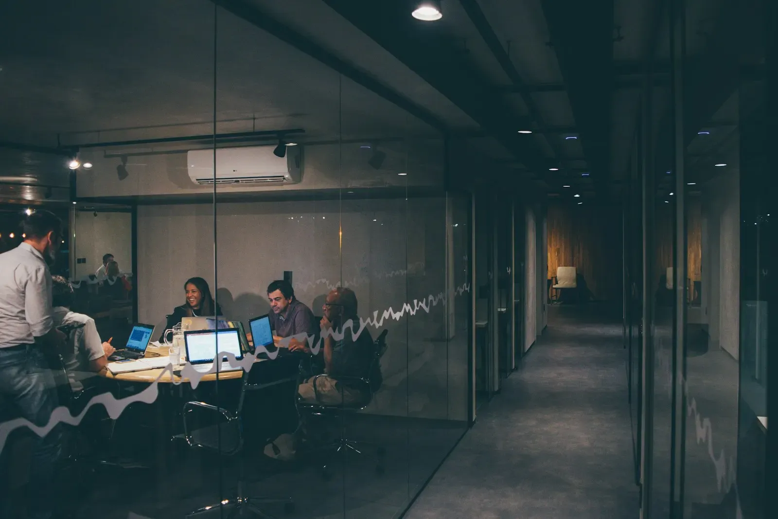 Team meeting in a dim office around laptops