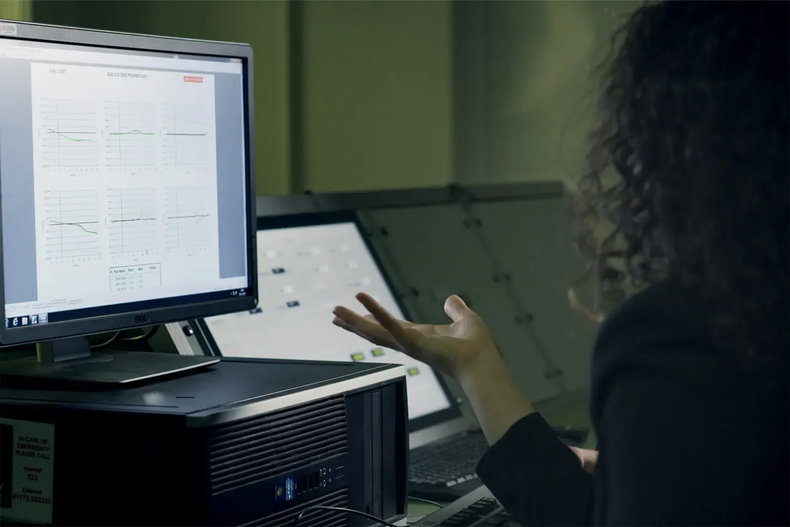 Engineer reviewing charts across two monitors