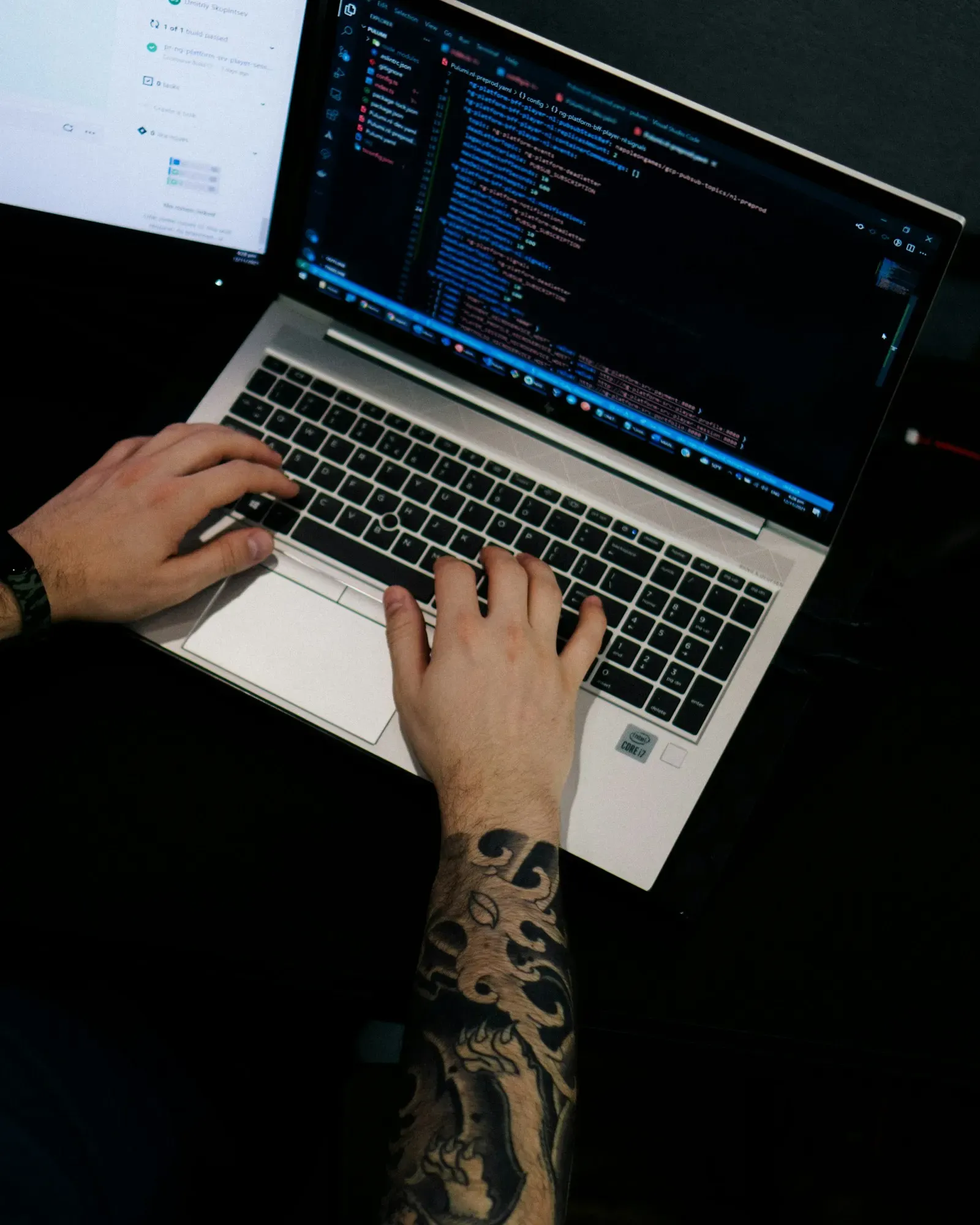 Engineer typing on a laptop in a dark room