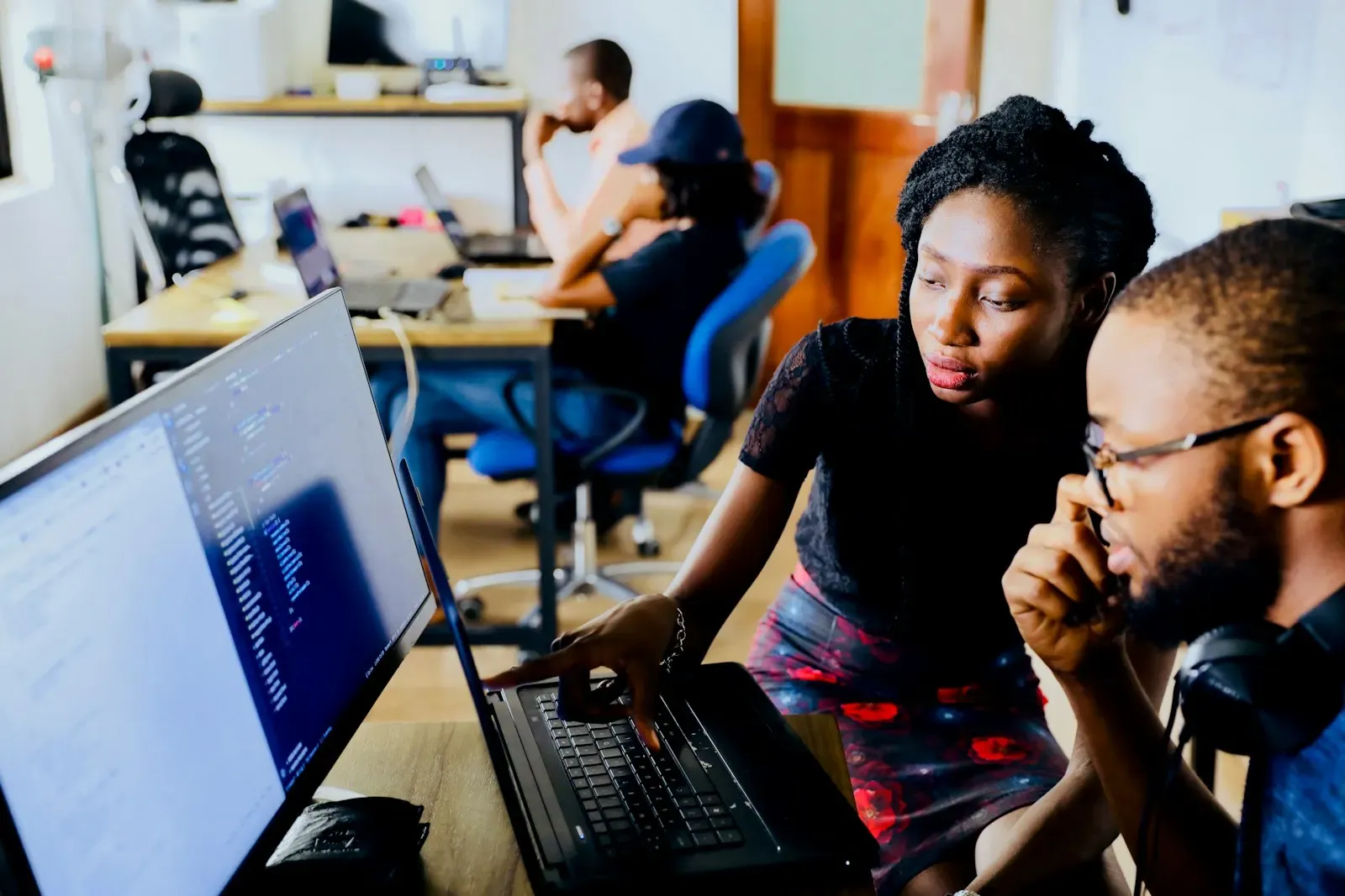 Two analysts reviewing data on a monitor together