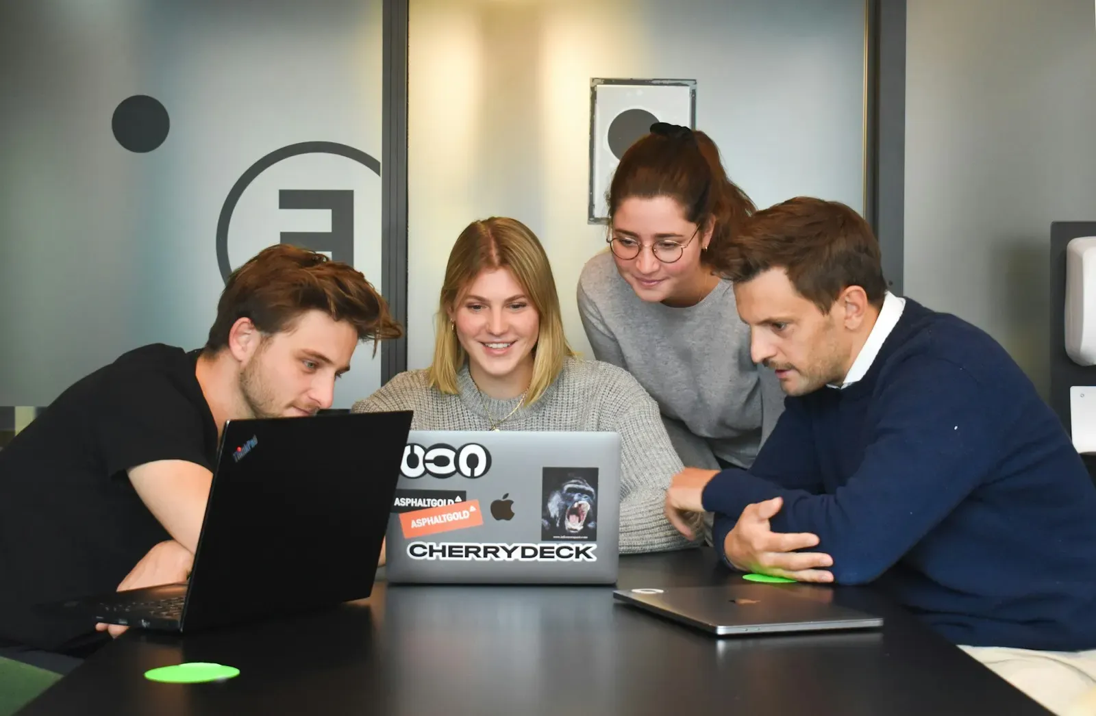 Product team gathered around a laptop in their office