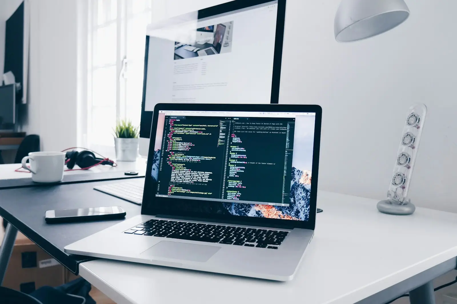 Laptop showing code on a tidy developer desk