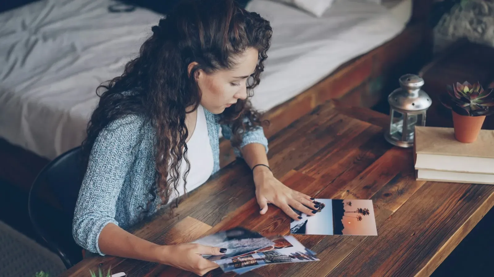 Woman sorting printed photos on a wooden table
