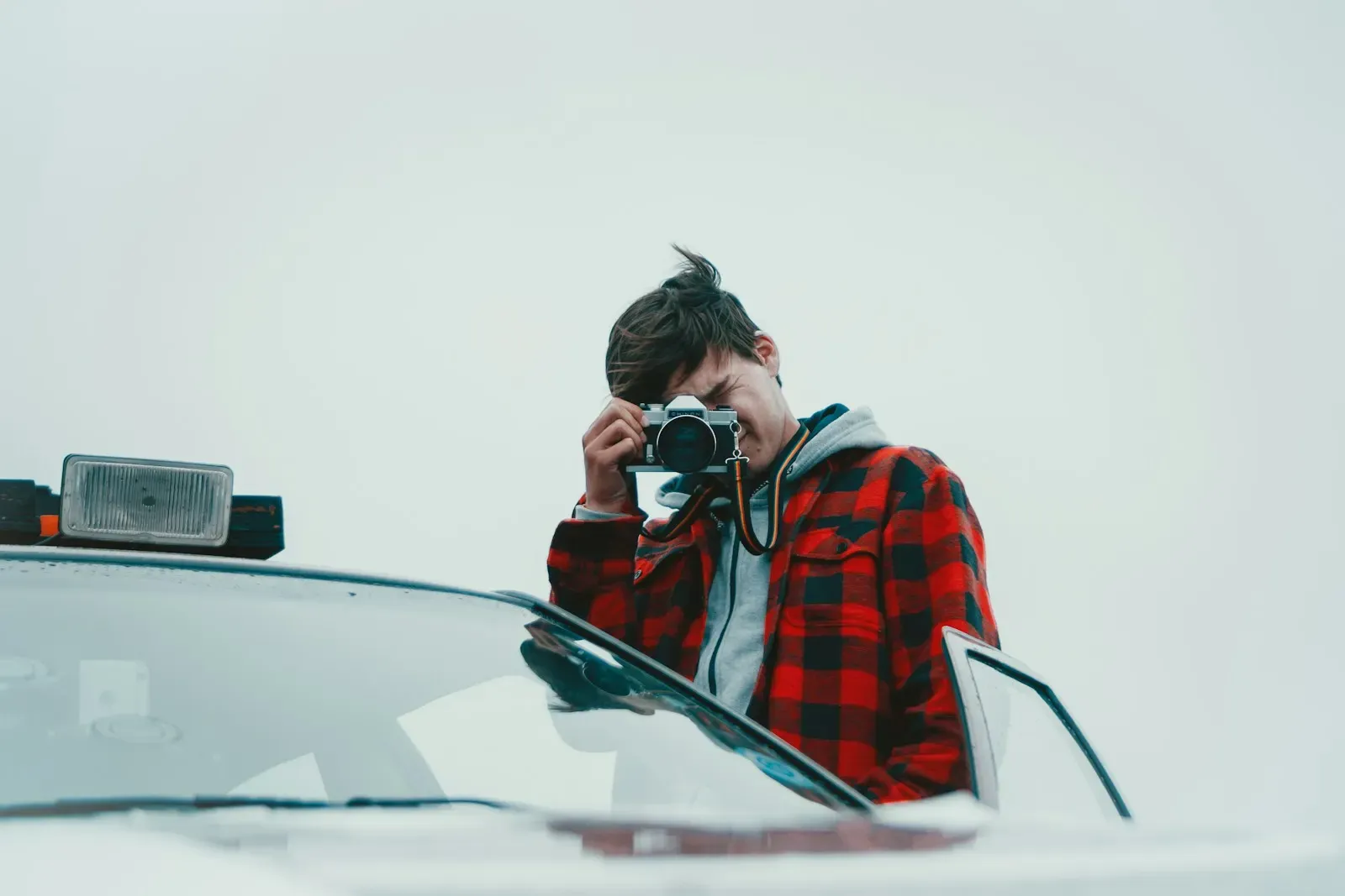 Person photographing a car with a camera