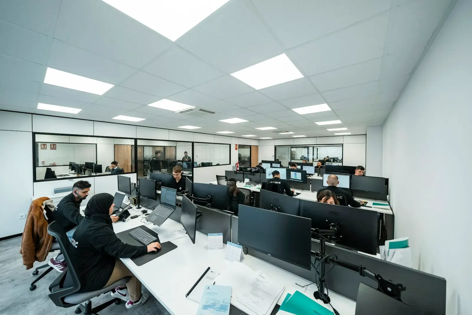 Open office with teams working at rows of computers