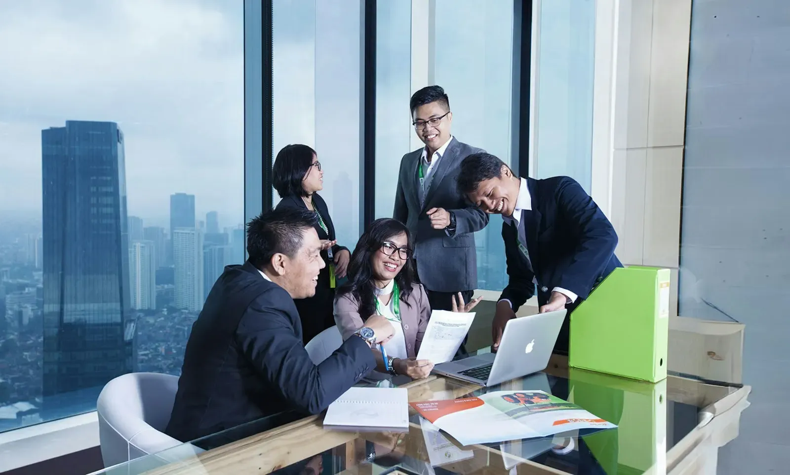 Team reviewing documents together at a desk by the window