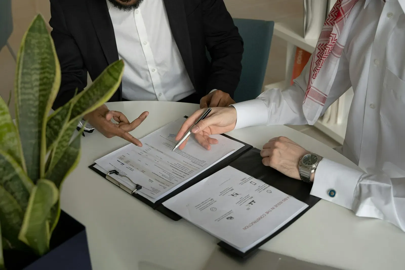 Two people reviewing compliance paperwork at a desk