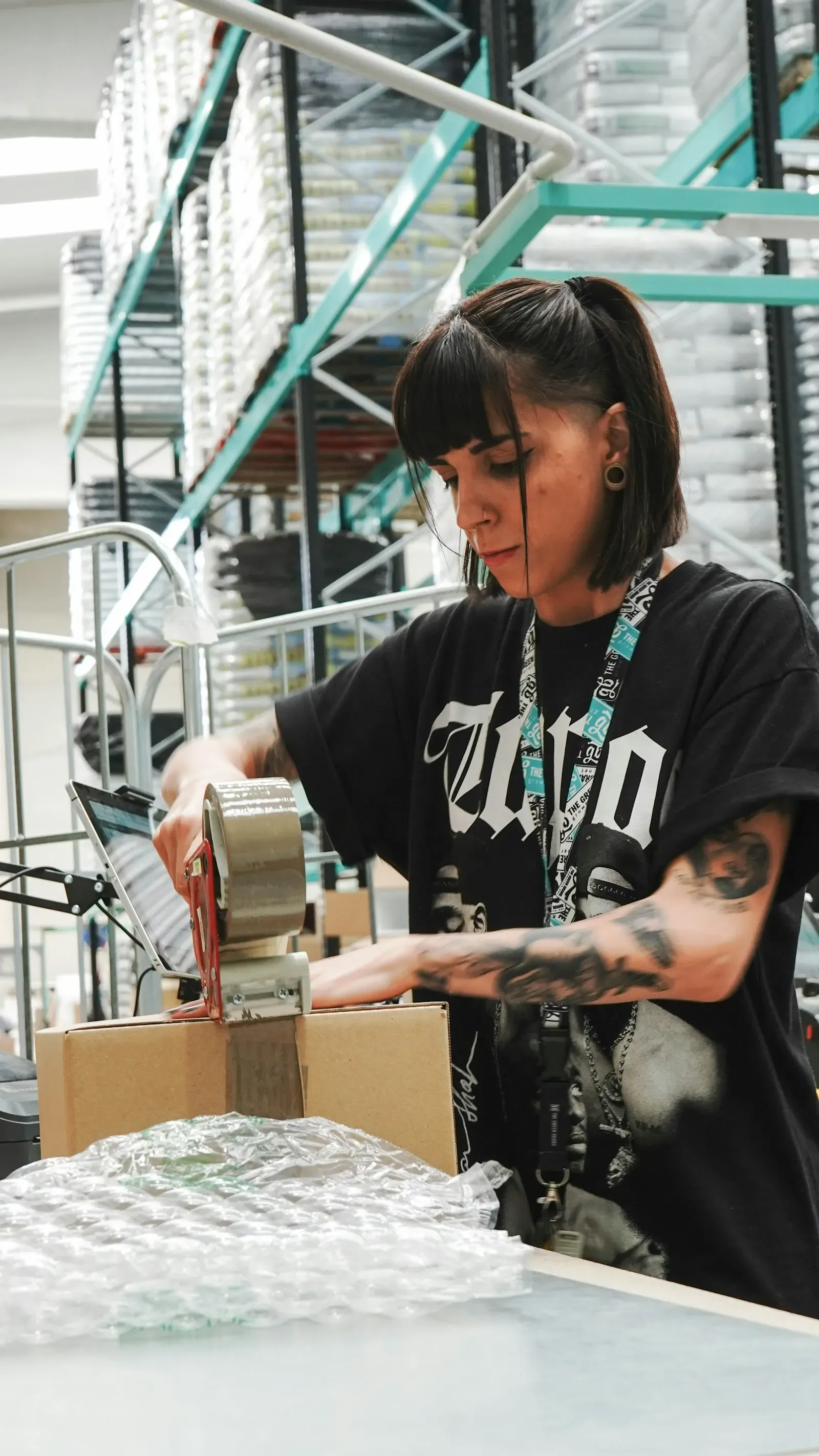 Warehouse worker taping a parcel for a delayed order