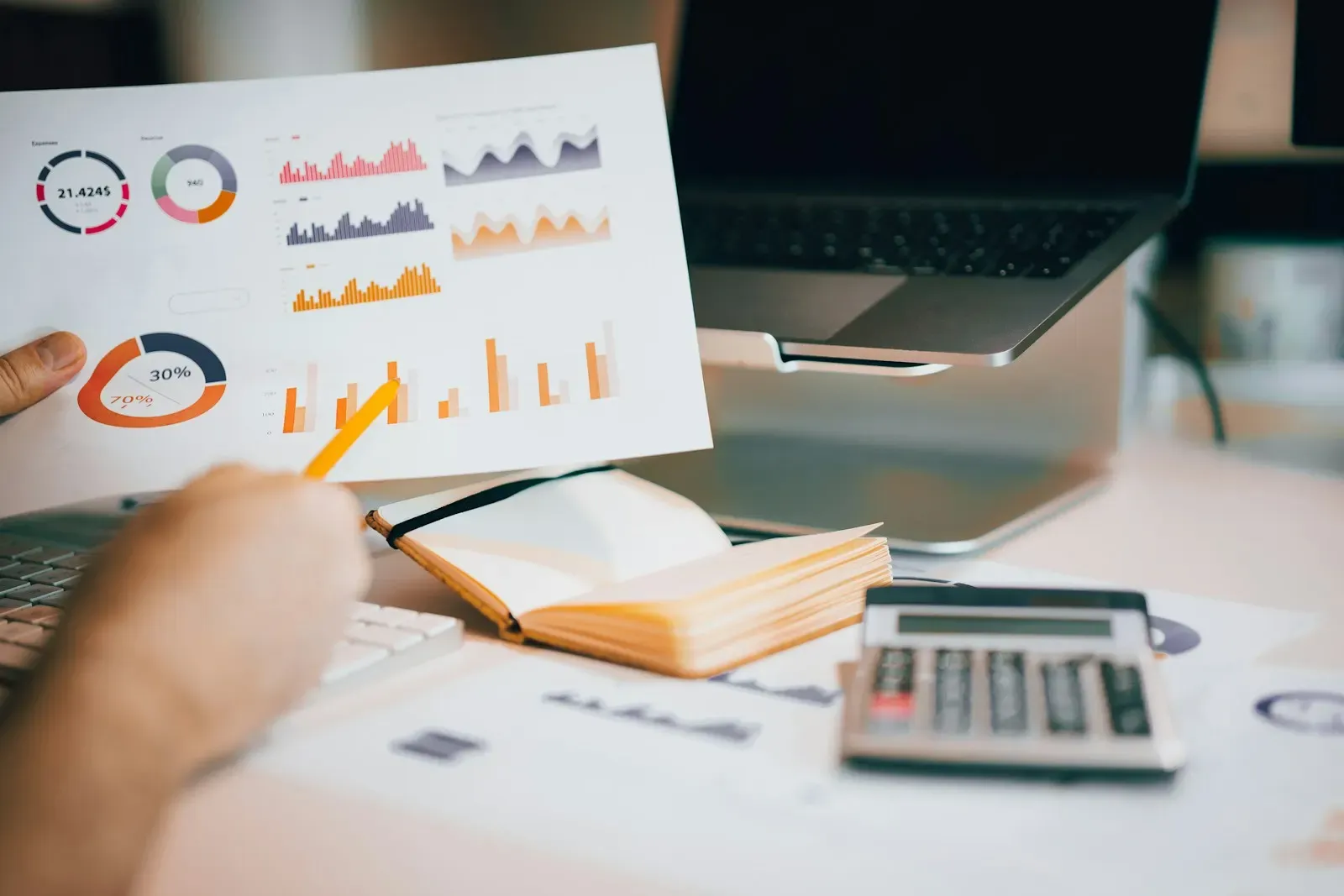 Reviewer checking printed charts beside a laptop