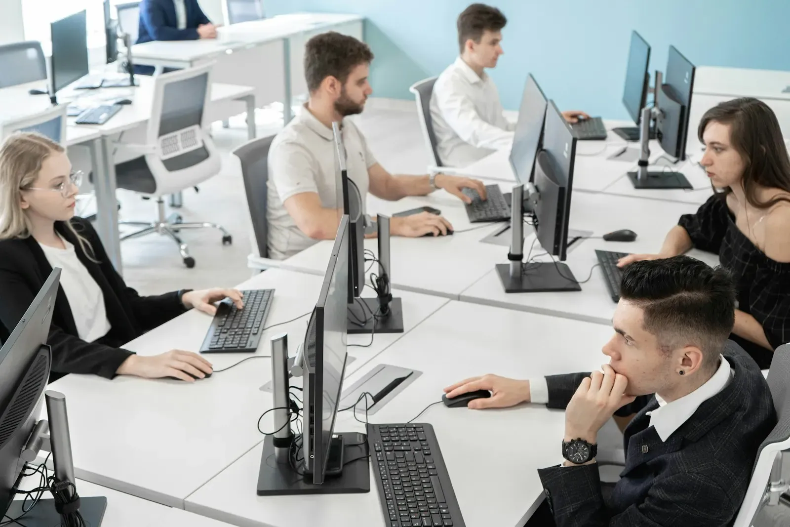 Office team working at rows of desktop computers