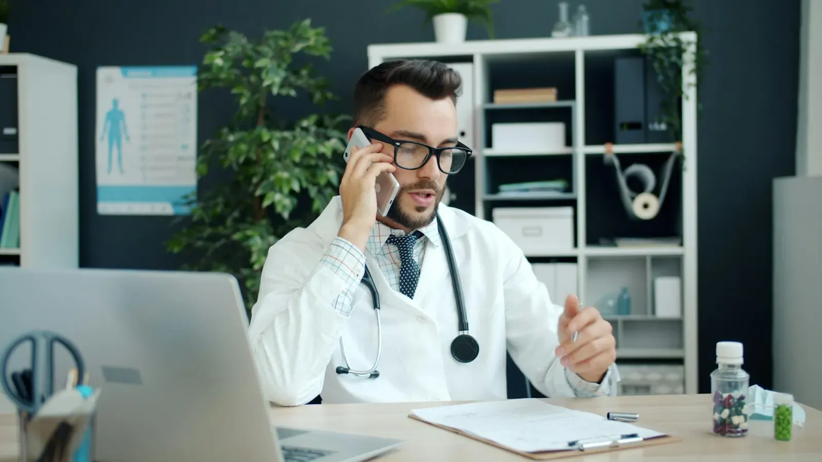 Doctor taking a patient call at his desk