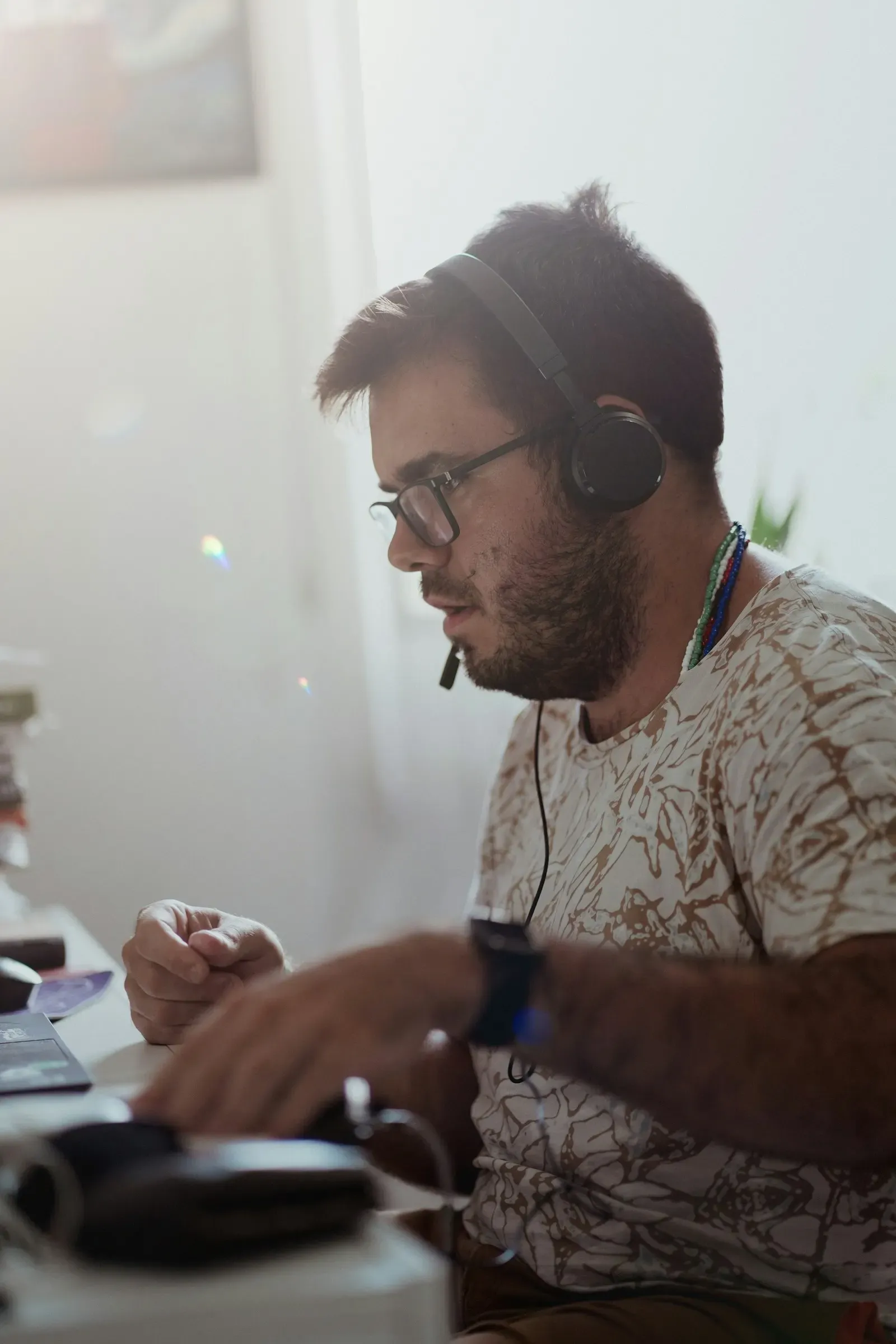 Support agent with a headset listening at his desk