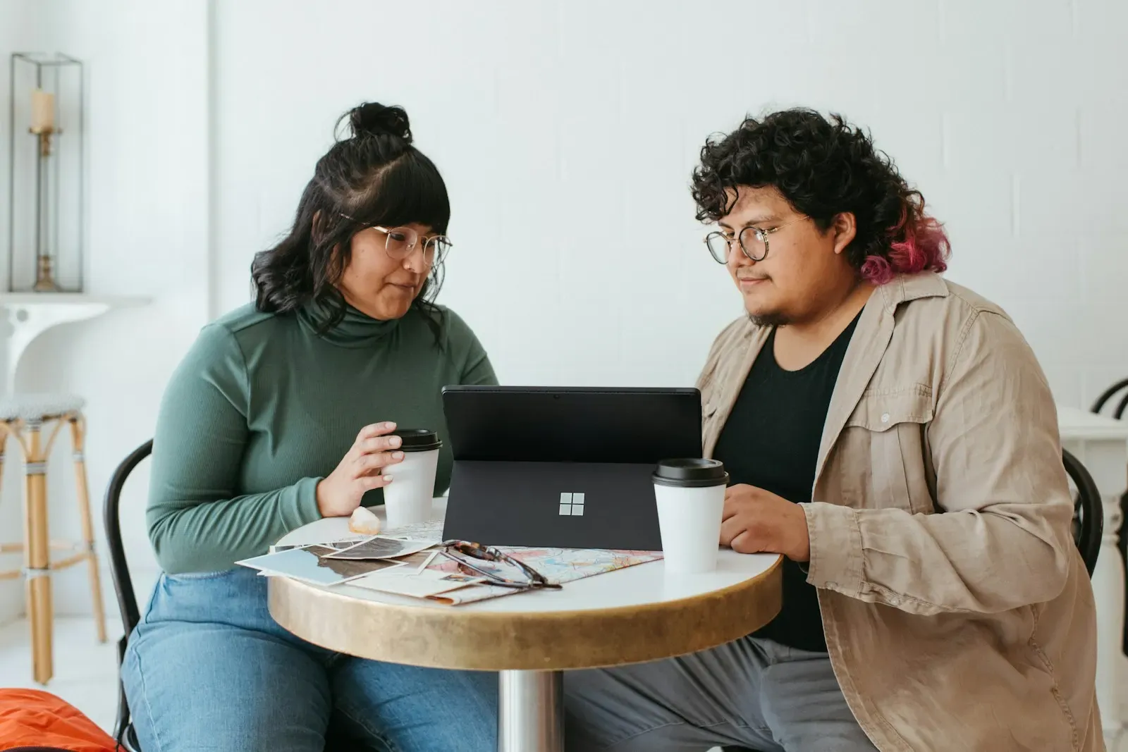 Two women talking at a table with a laptop
