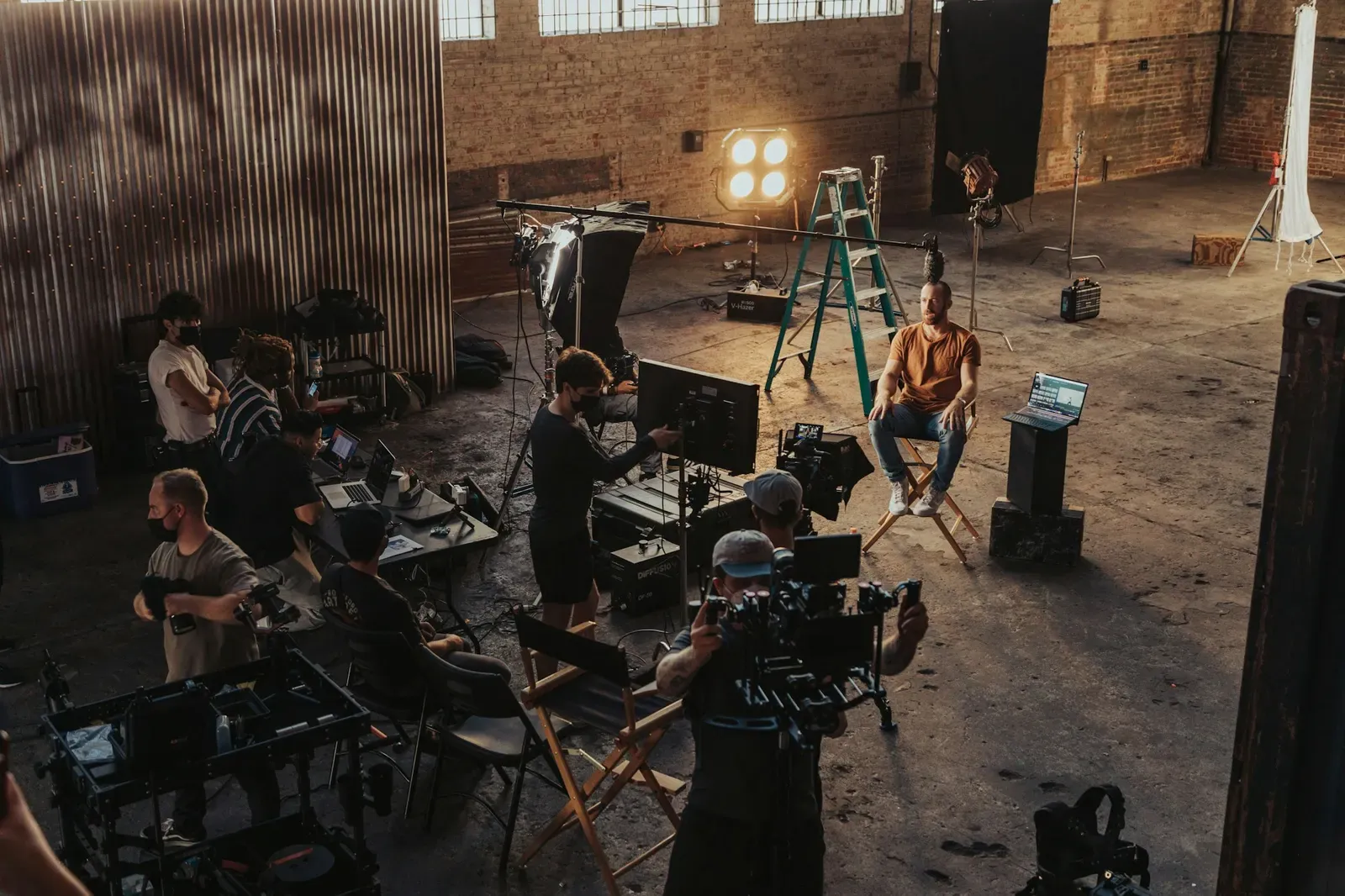Film crew working together around cameras and lights on a set