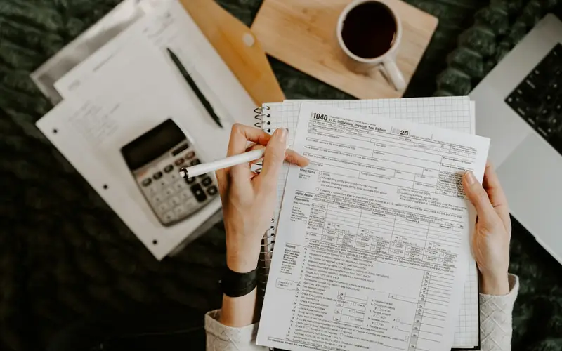 Finance professional reviewing documents with a calculator