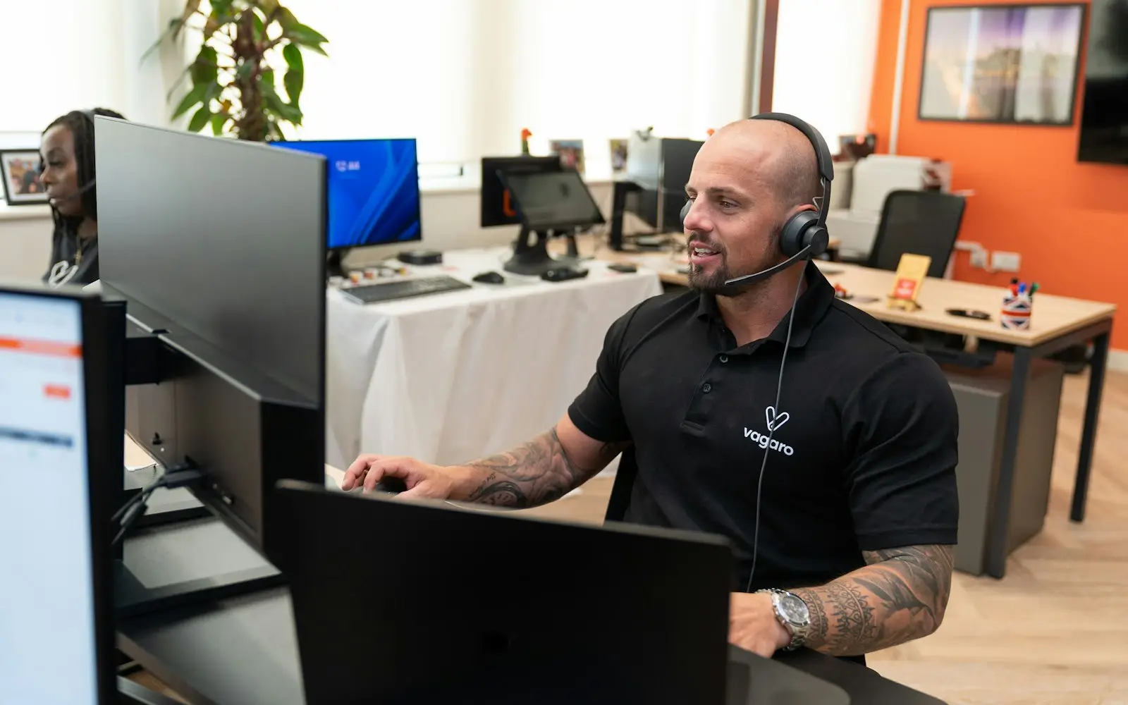 Support agent with a headset working at a computer